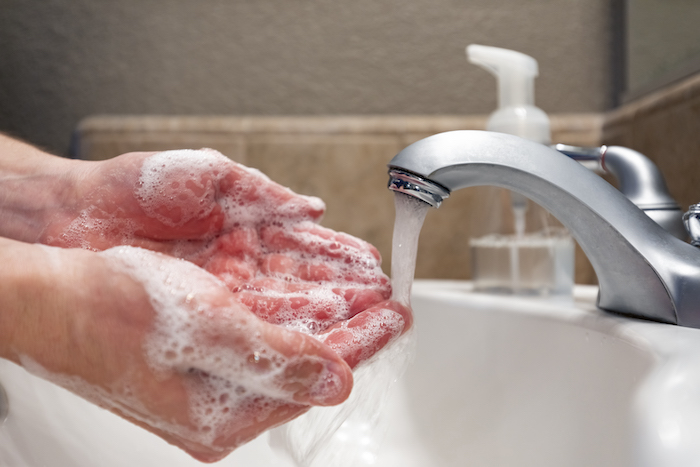 A person with anxiety disorder behaving with obsessive compulsive disorder washing hands until they turn red.